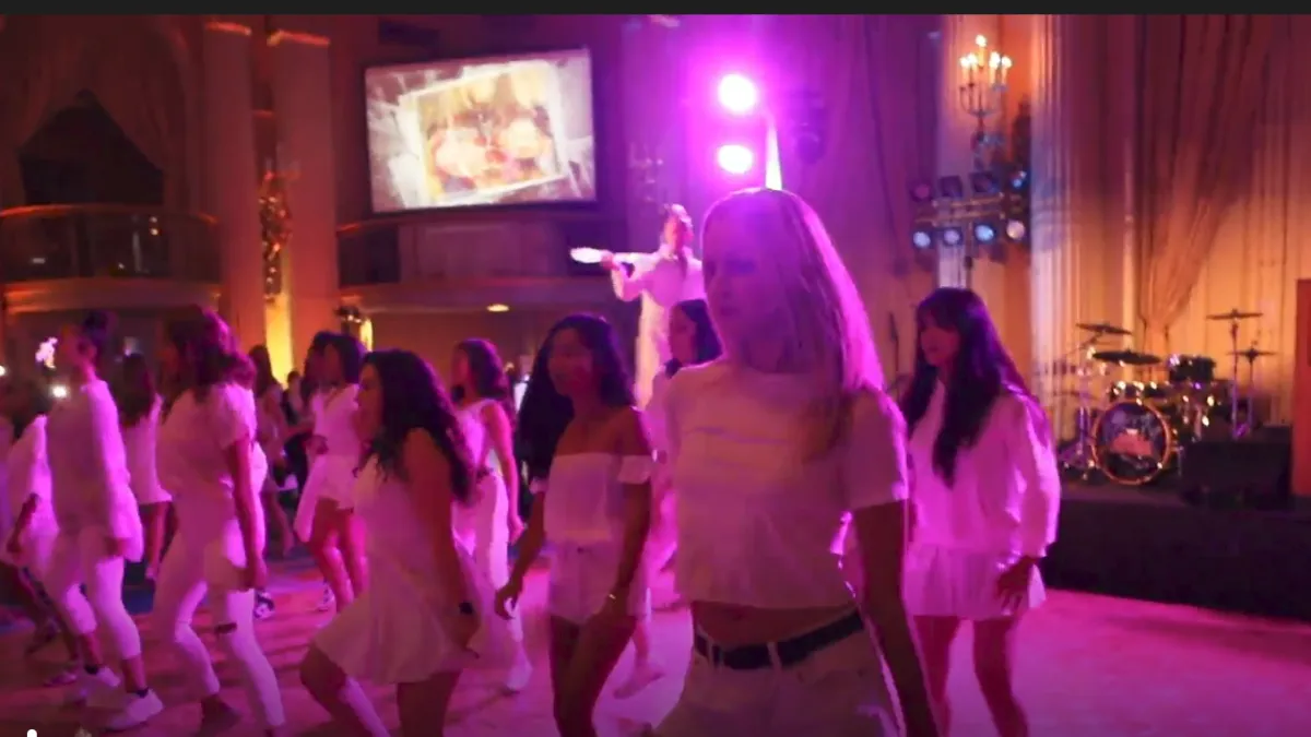 Flash mob dancers at a corporate product launch with branded stage lighting